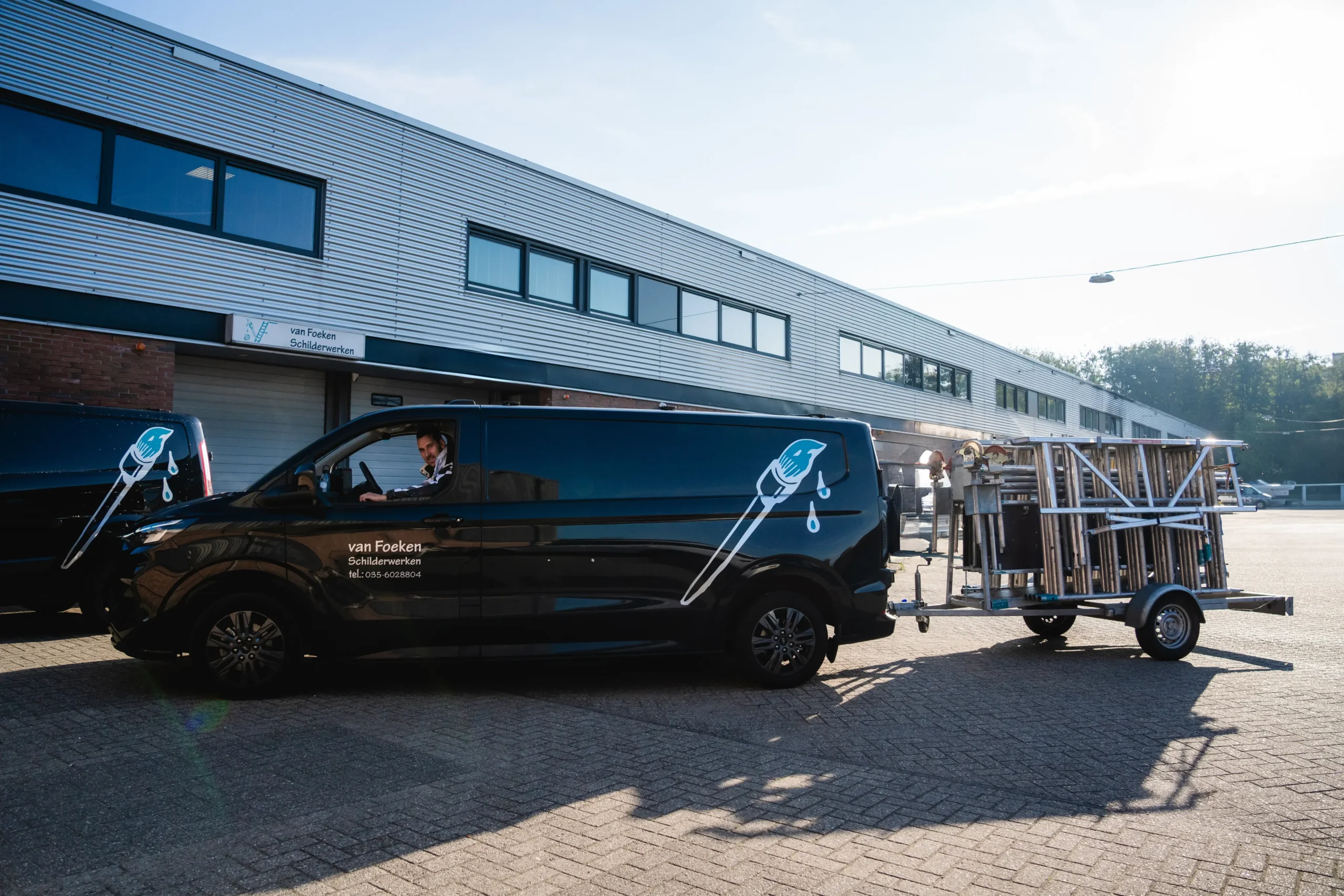 Bus en aanhanger van Van Foeken Schilderwerken voor een bedrijfspand