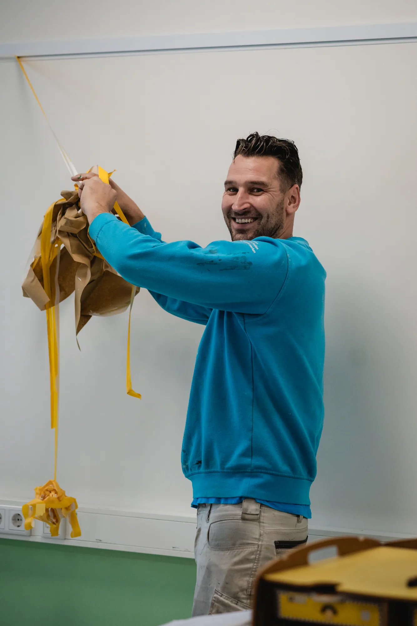 Schilder van Van Foeken plakt een wand af voor strak schilderwerk