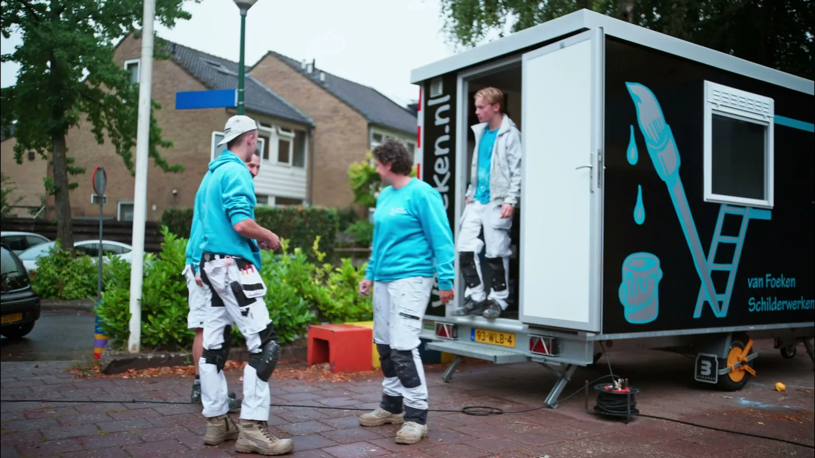 Het team van Van Foeken bij de werkwagen op een schoolplein