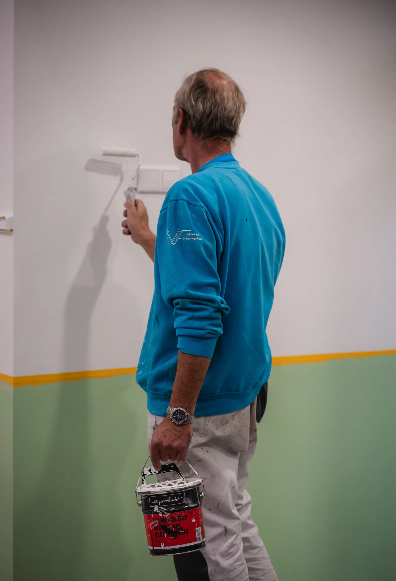 Schilder van Van Foeken rolt een wand strak in twee kleuren
